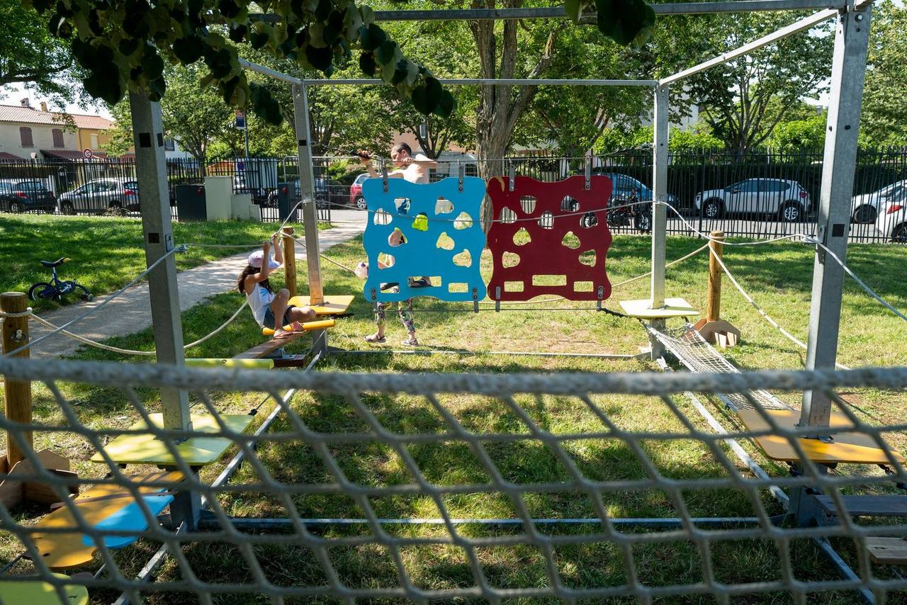 Parcours accrobranche mobile installé en extérieur, avec panneaux d'escalade et enfants en train de jouer
