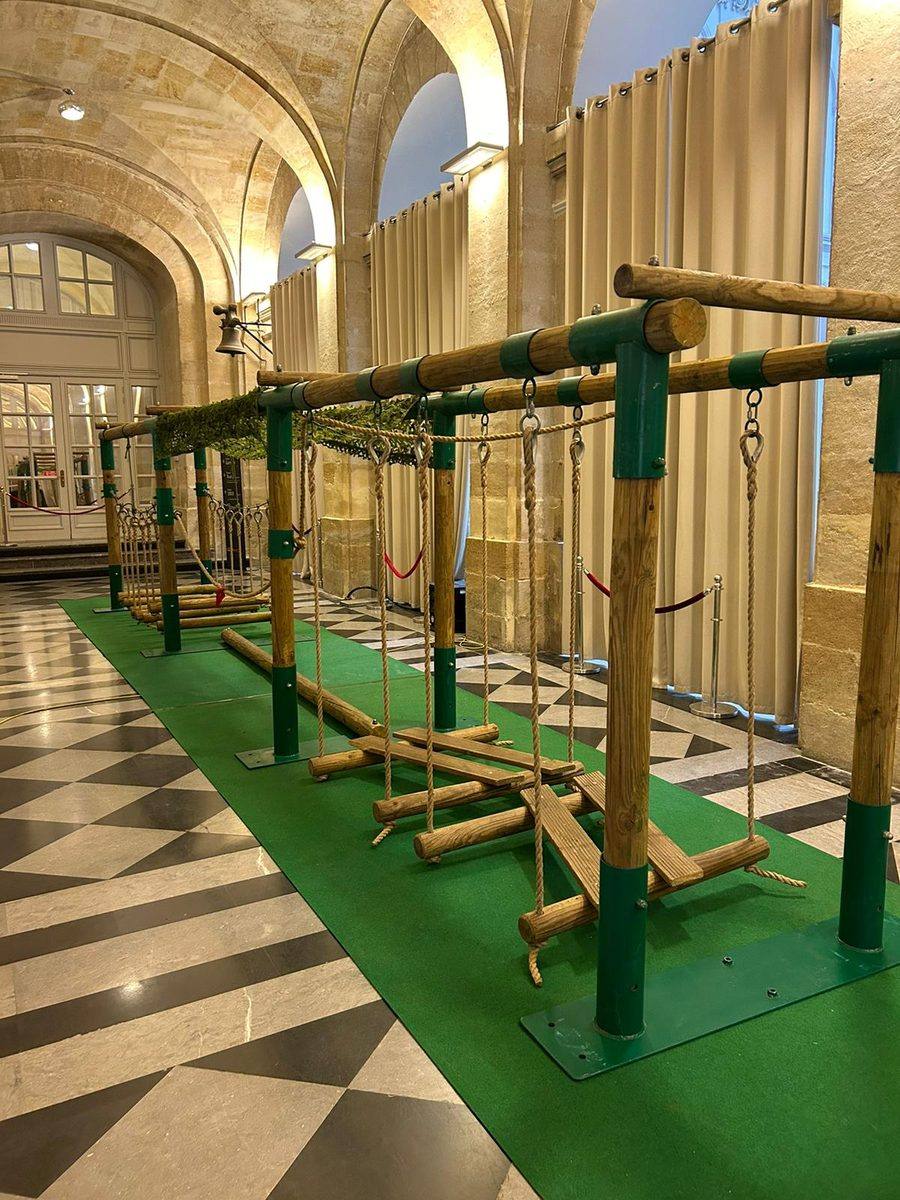 Structure d'accrobranche autoportée en rondins, avec passerelles suspendues, installée en intérieur