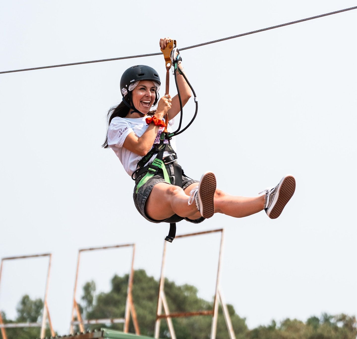 Nos valeurs : une participante rit en descendant une tyrolienne Alturismo