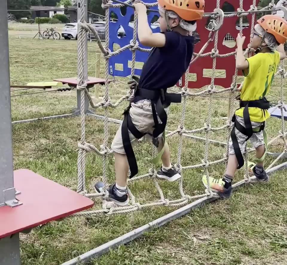 Enfants sur un parcours d'accrobranche mobile installé en plein air