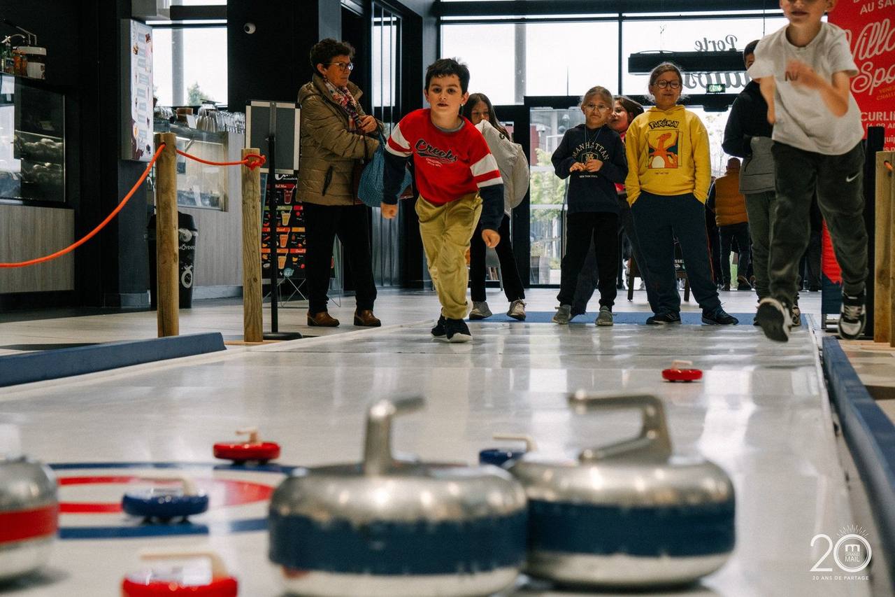 Partie de curling sur piste synthétique installée dans une galerie commerciale