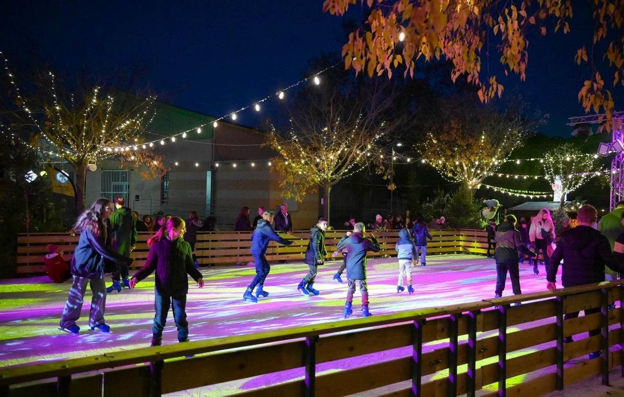 Patinoire synthétique en extérieur, ambiance nocturne avec guirlandes lumineuses