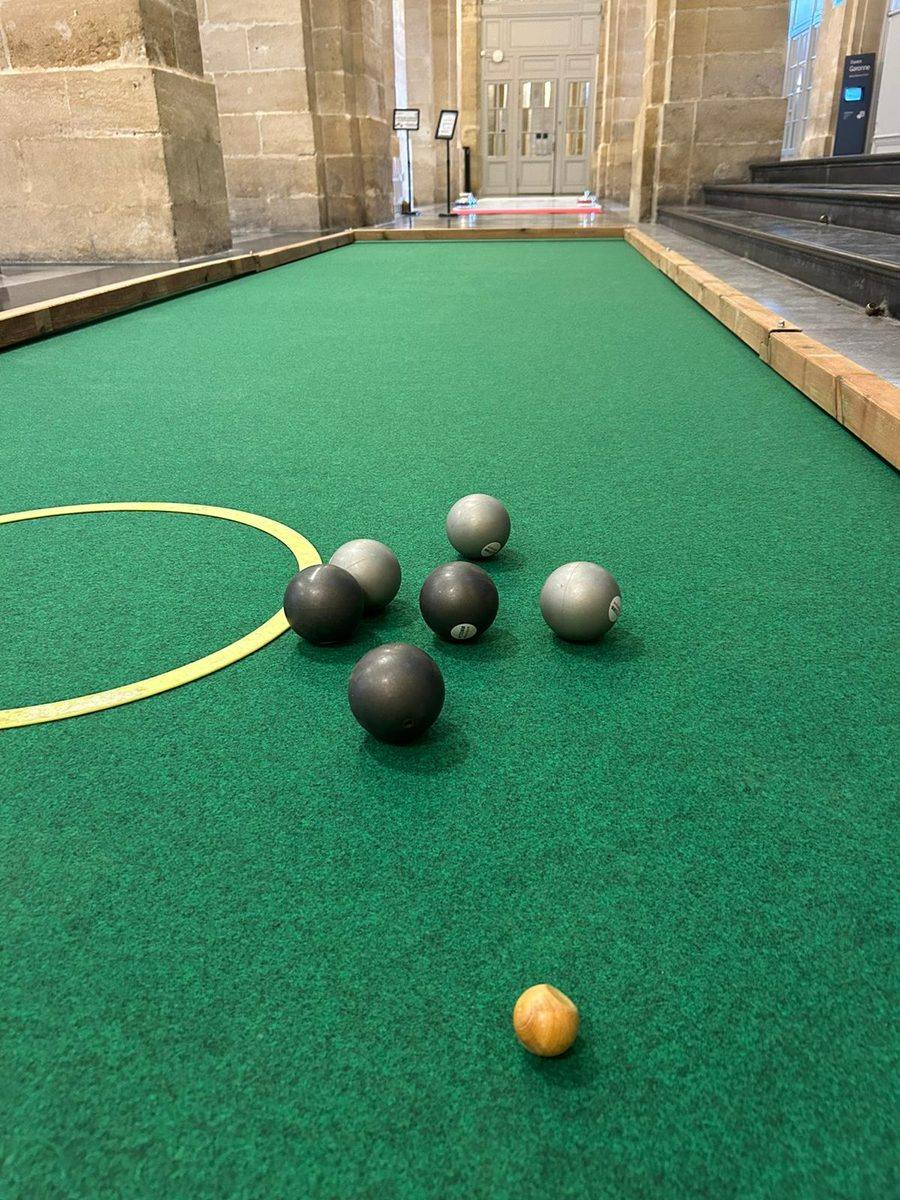 Boules de pétanque indoor souples et cochonnet en bois sur la moquette verte